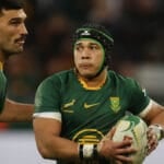 Springboks wing Cheslin Kolbe carries the ball in green and gold, watched by a team-mate