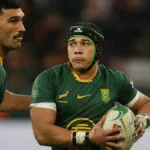 Springboks wing Cheslin Kolbe carries the ball in green and gold, watched by a team-mate