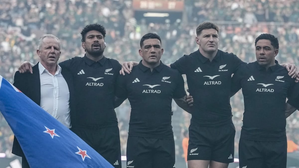 He was 63 years old, standing on the Ellis Park grass with the New Zealand flag in his hands and no real idea where he was meant to put himself. The anthems were about to start. Sixty-two thousand people were waiting. And the former All Blacks captain was, by his own account, stuck. Then Ardie Savea put an arm around him and pulled him into the line.