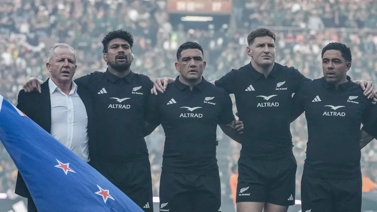 He was 63 years old, standing on the Ellis Park grass with the New Zealand flag in his hands and no real idea where he was meant to put himself. The anthems were about to start. Sixty-two thousand people were waiting. And the former All Blacks captain was, by his own account, stuck. Then Ardie Savea put an arm around him and pulled him into the line.