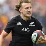 Damian McKenzie running with the ball in an All Blacks jersey
